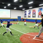Young athletes training at Hitclub indoor baseball facility, showing energy and teamwork in action.