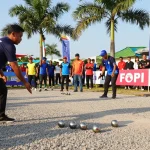 Players competing at FOPI Kota Palu outdoor petanque tournament, showcasing community spirit and sportsmanship.